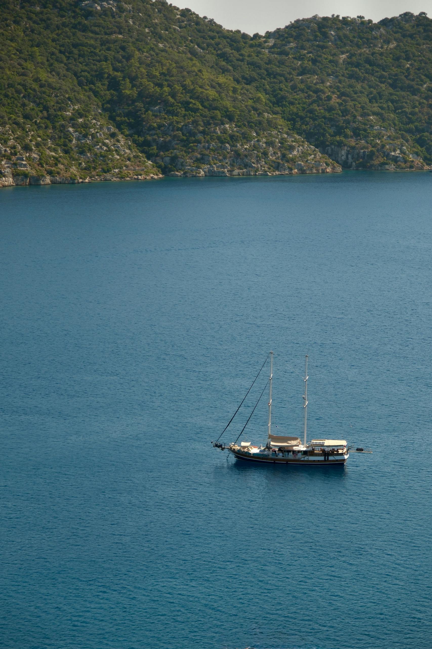 A picturesque view of a sailing boat in the tranquil blue waters near Kaş, Antalya, Türkiye.
